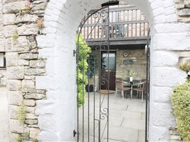 Un arco de piedra que conduce a un edificio con el letrero "The Hayloft".
