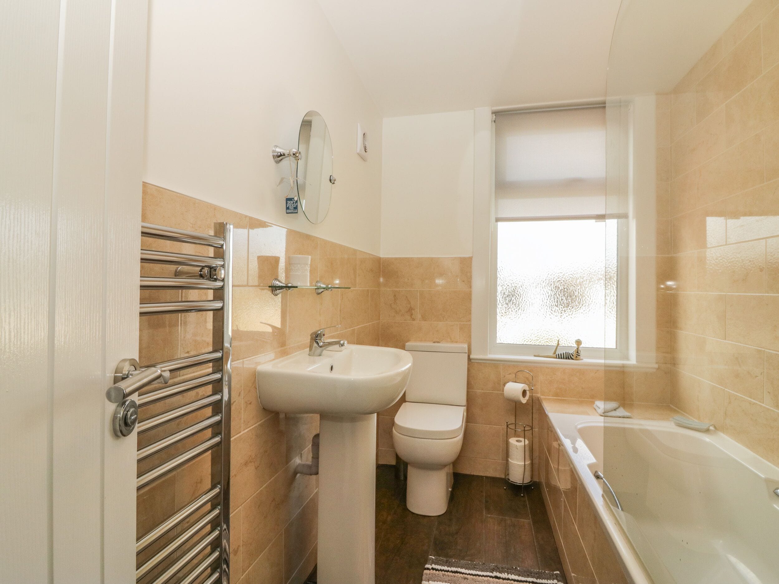 A bathroom with a toilet, sink, and bathtub.