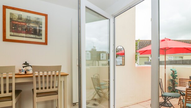 Une pièce dotée d’une porte-fenêtre coulissante donnant sur un patio extérieur.