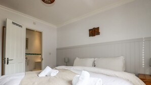 Una camera d'albergo con un letto grande, un ingresso alla toilette e un piccolo ornamento a parete.