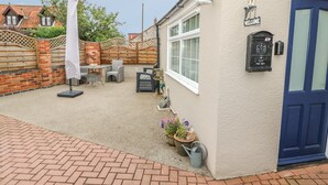 A patio area with outdoor furniture, a mailbox, and a welcome sign. - Bertelle (King's Lynn)