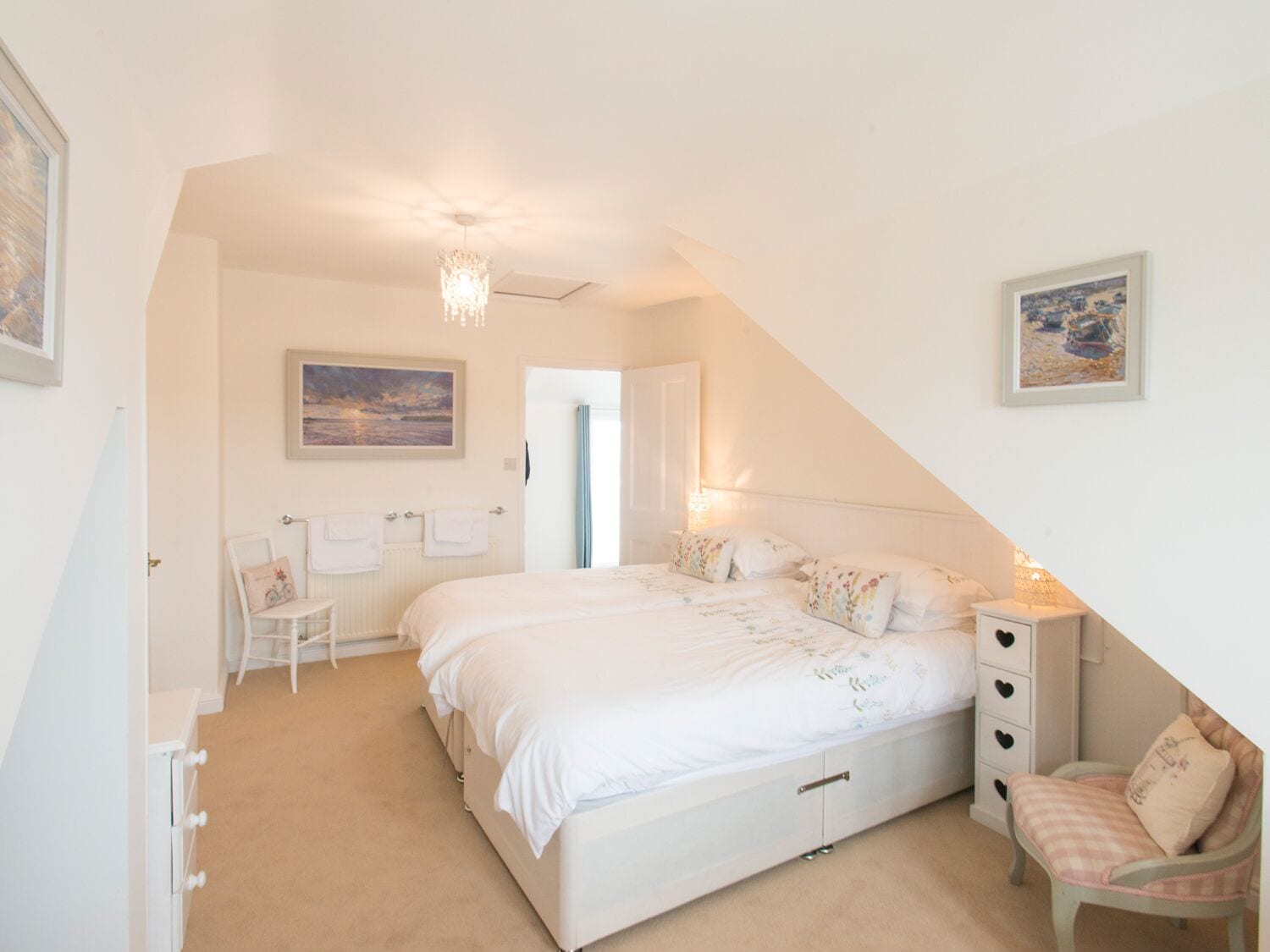 A bedroom with a large bed, a chair, a dresser, and a nightstand.