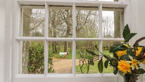 Janela com vista para um jardim e um letreiro.