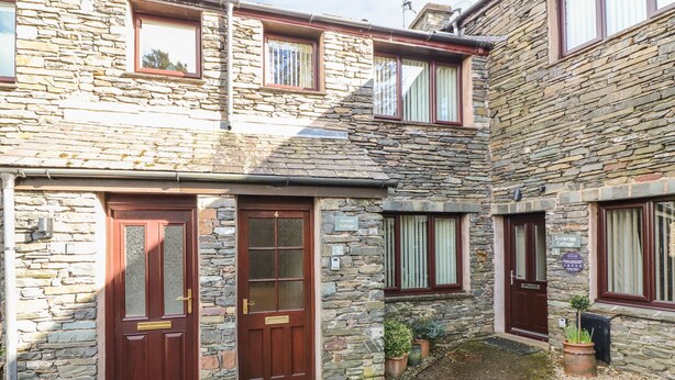 A stone building with two doors and windows, labeled as 'Jumper Cottage' and 'Eccleree Cottage'. - Juniper Cottage (Ambleside)