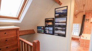 A staircase with wooden railings, a wooden dresser, and a skylight. - Granary Nook (Windermere)