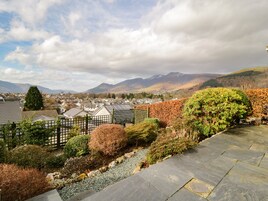 A residential area with houses, a stone pathway, and a view of mountains.