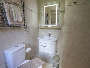 Ein Badezimmer mit Toilette, Waschbecken und Handtuchhalter.