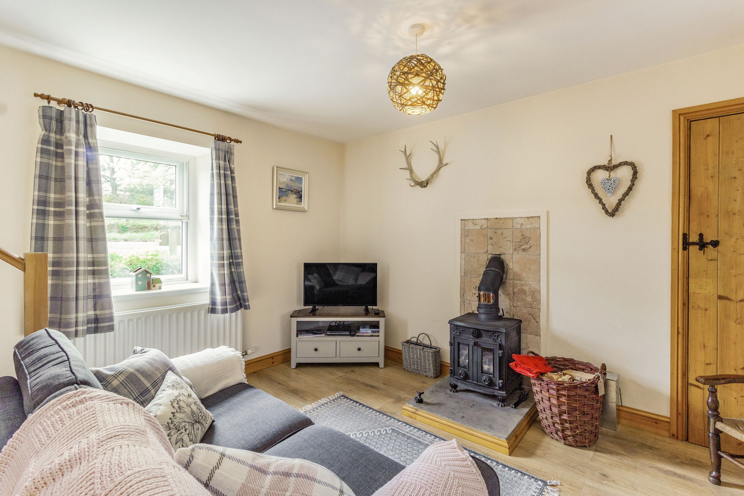 A cozy living room with a sofa, television, fireplace, and decorative wall art.