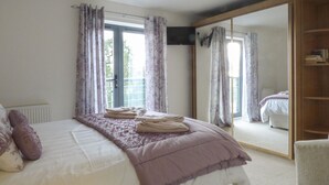 Une chambre à coucher avec un lit, une armoire et un grand miroir.