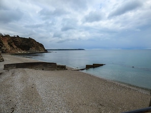 Enjoy a serene beach experience with a pebble beach and calm waters.