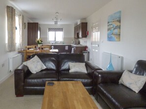 Relax in this stylish living room with a comfortable sofa set, coffee table, and dining area.