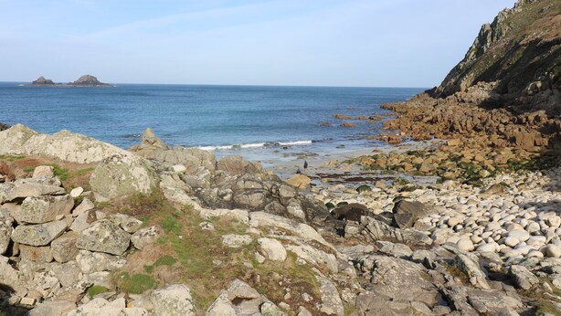 A rocky coastal landscape with a clear view of the sea and distant islands. - Mollys Cottage (Penzance)