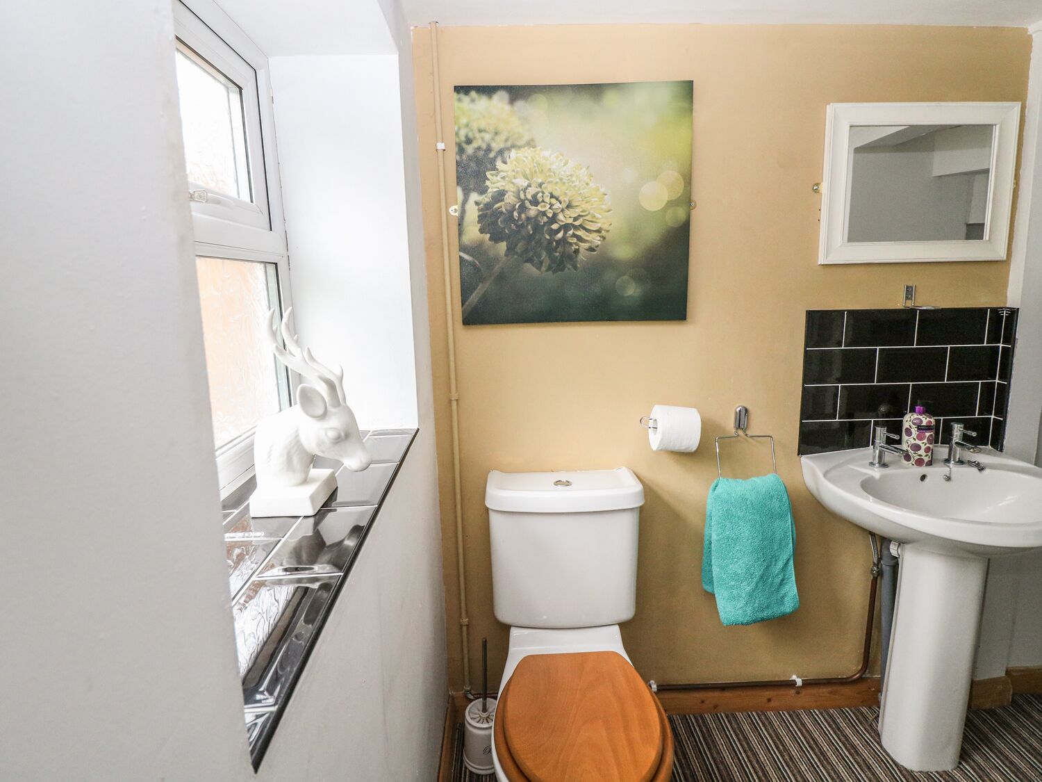 Une petite salle de bain comprenant des toilettes, un lavabo et une fenêtre.