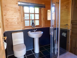 A bathroom with a toilet, sink, and shower.