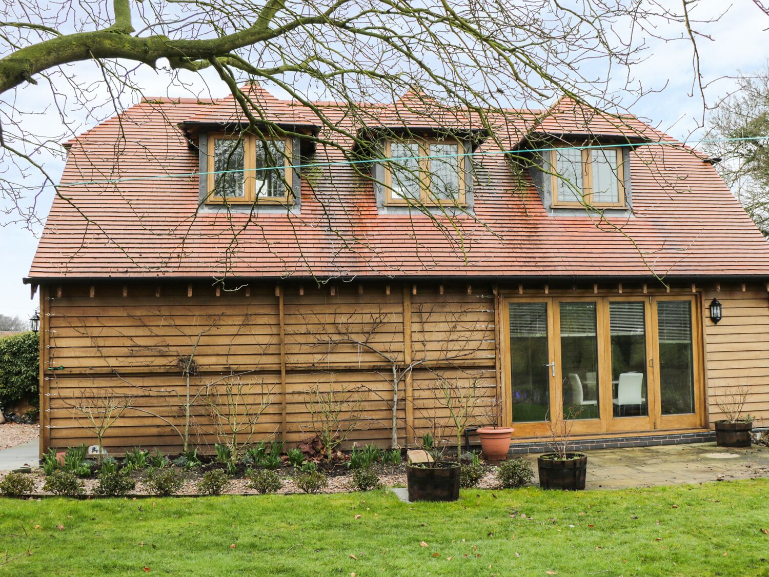 A wooden house with a sloped roof, two windows, and a glass door.