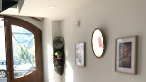 A wooden bench in a hallway with a door leading outside. There are framed pictures on the wall. - Apartamentos De Montaña Mendiola (Valcarlos)