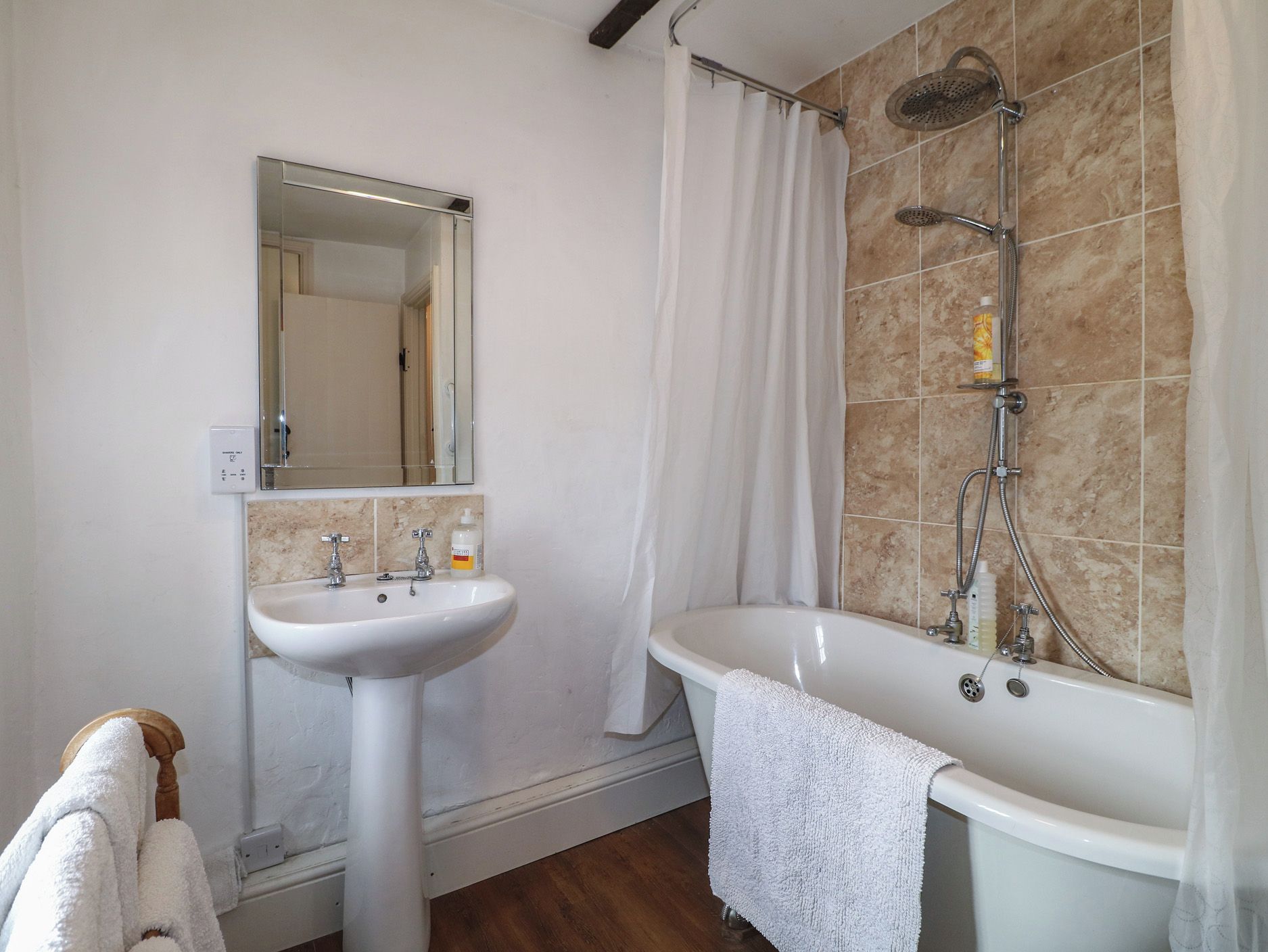 A bathroom with a sink, mirror, shower, and bathtub.