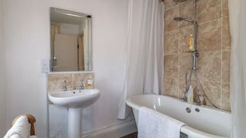 A bathroom with a sink, mirror, shower, and bathtub.