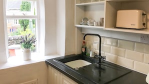 Een keuken met een raam, een spoelbak en een Bosch-toaster op het aanrecht.