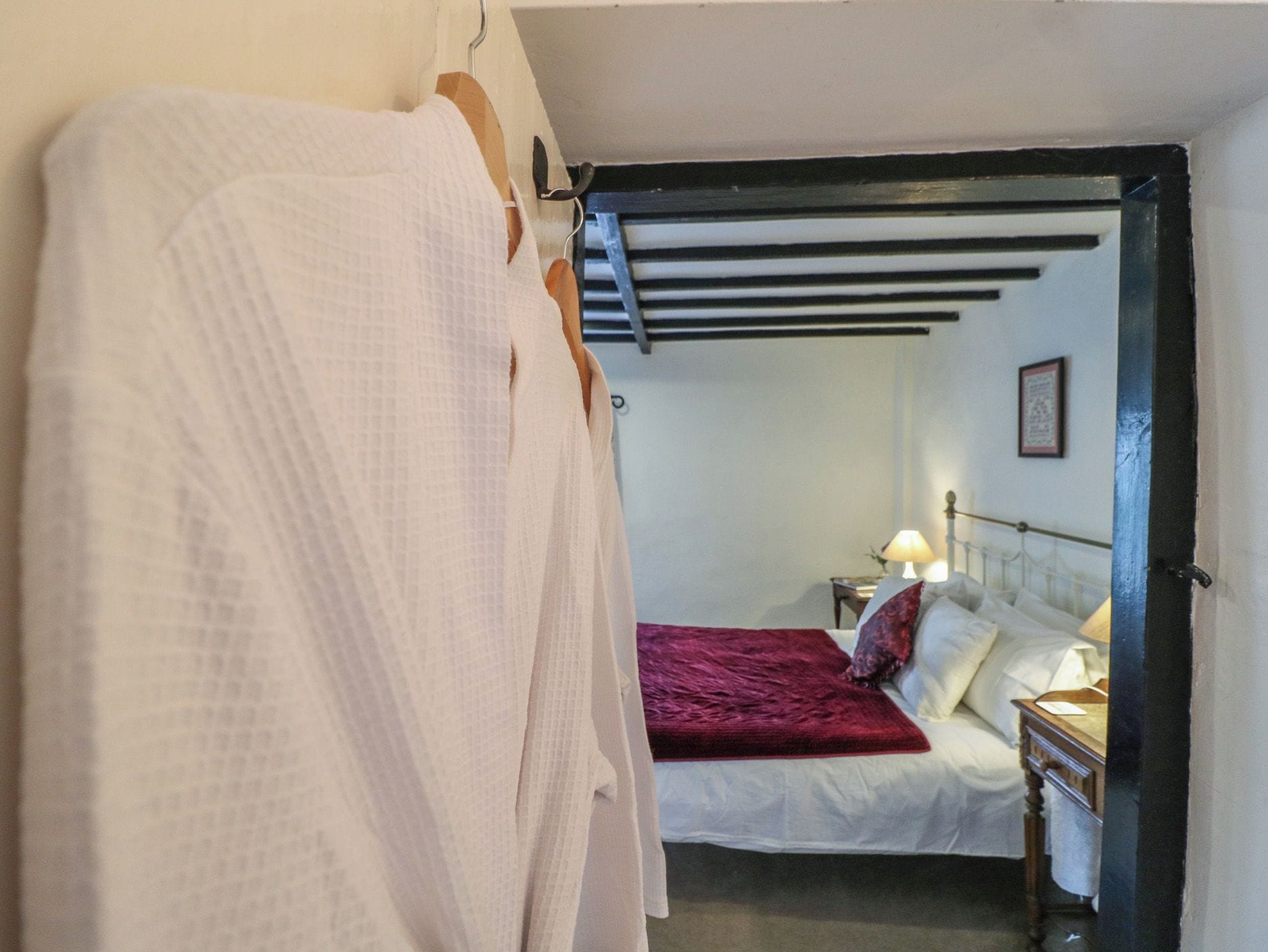 Une chambre à coucher avec un lit, une table de chevet, une lampe et une fenêtre.
