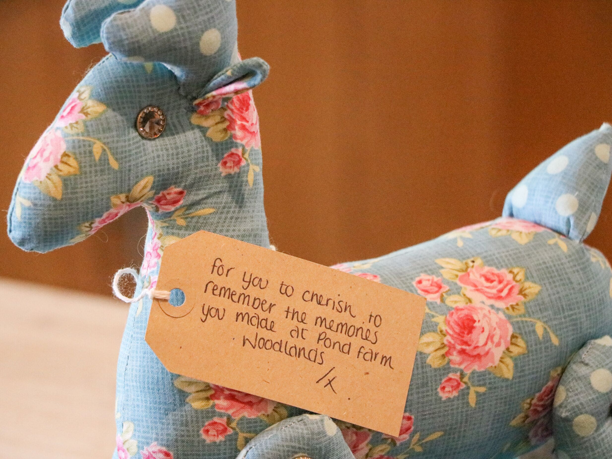 Un jouet en peluche orné d’un motif floral et muni d’une étiquette.