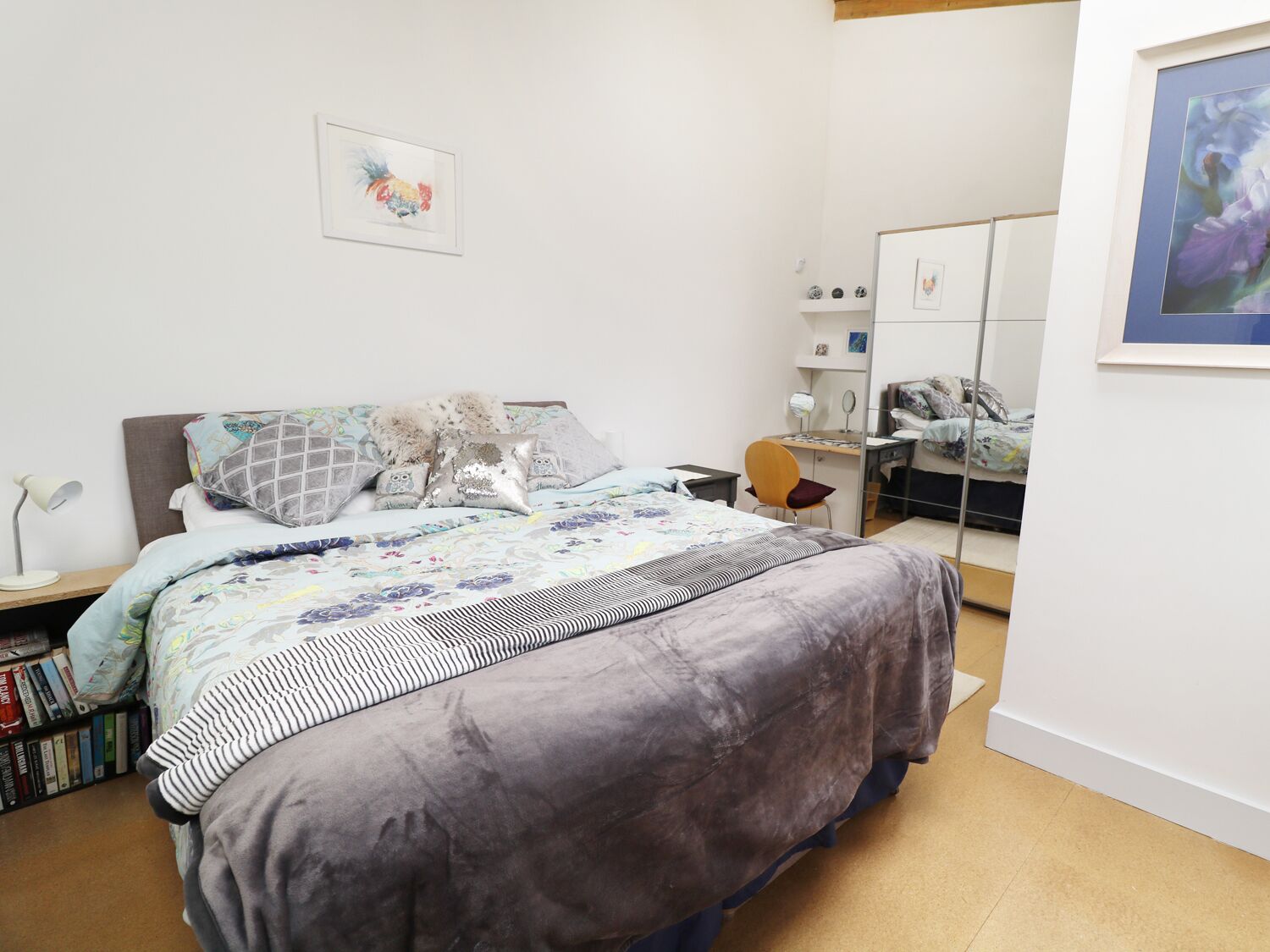 Ein Schlafzimmer mit Bett, Schreibtisch, Stuhl und Bücherregal.