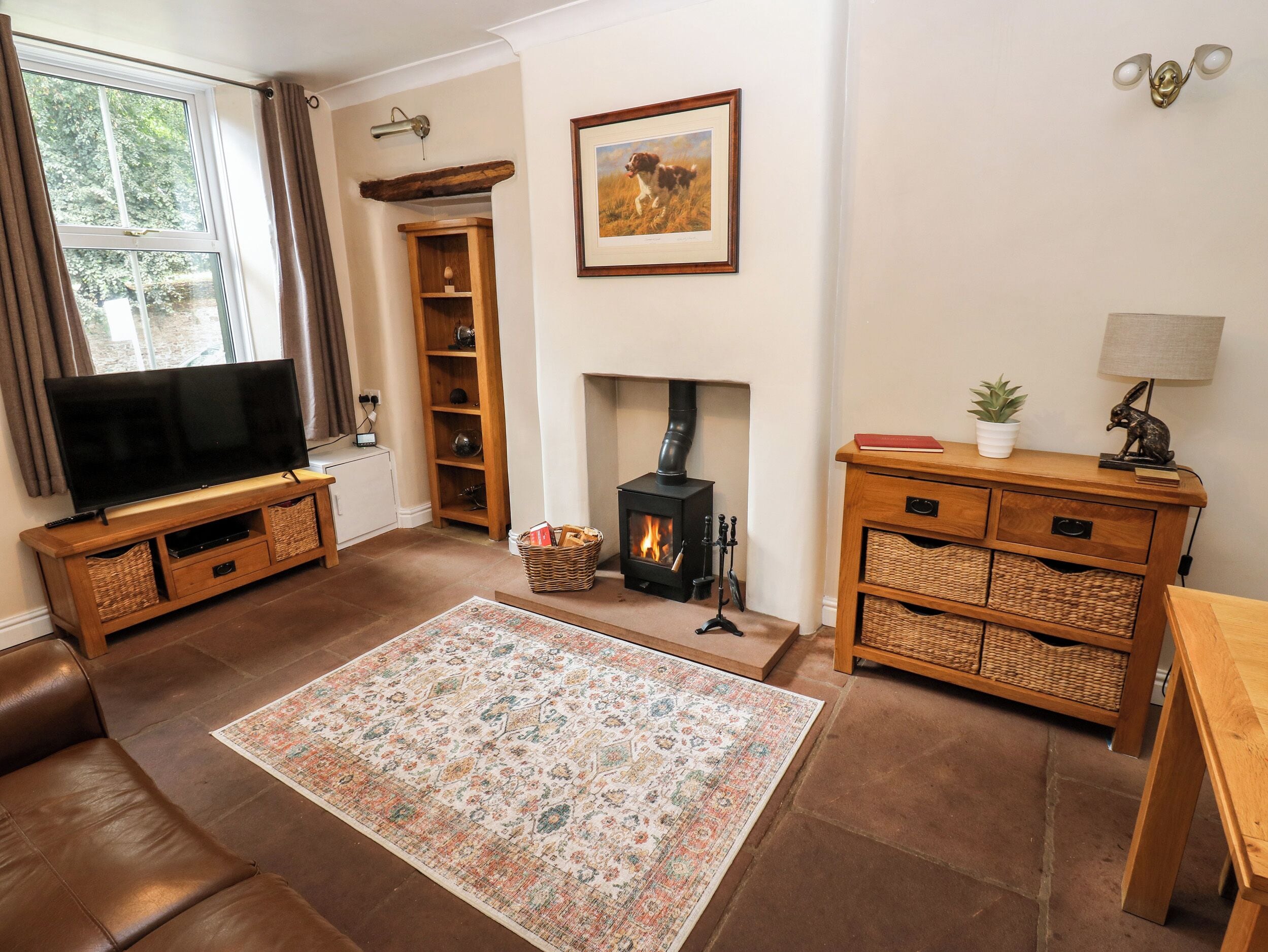 A living room with a television, fireplace, and wooden furniture.