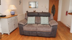 A modern living room with a brown leather sofa, a white cabinet, a lamp, and a mirror on the wall. - 6 Mill Wharf (Berwick-upon-Tweed)