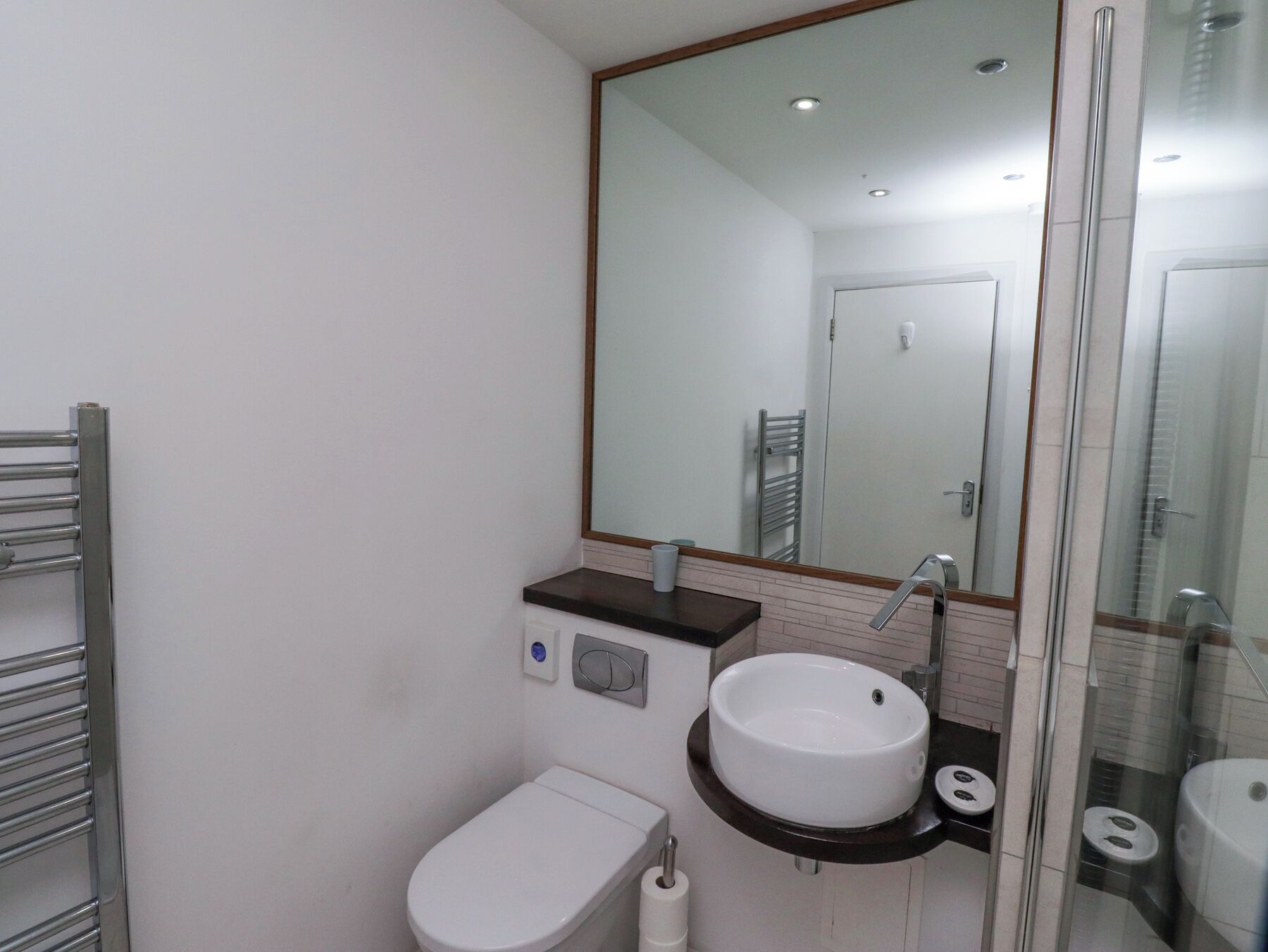A modern bathroom with a toilet, sink, and shower.