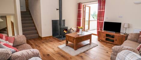 Una sala de estar acogedora con chimenea, televisor y asientos cómodos.