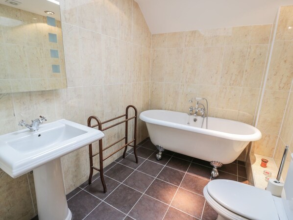 A bathroom with a freestanding bathtub, a sink, and a toilet. - Bracken Holiday Cottage (Dalbeattie)
