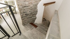 A stone staircase with a wooden handrail and a glass door leading to a patio area. - Oak Cottage (Barnard Castle)