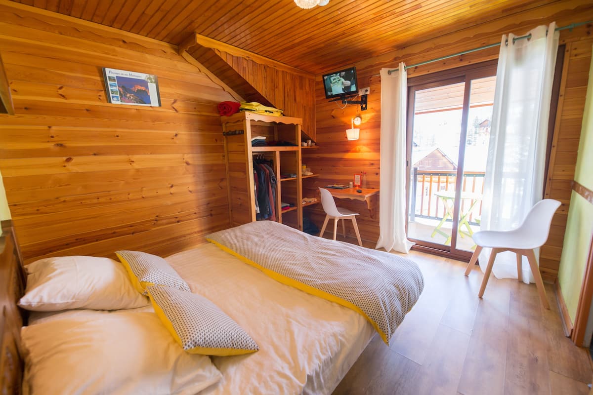 Una habitación de cabaña de madera con una cama, un escritorio y una silla.