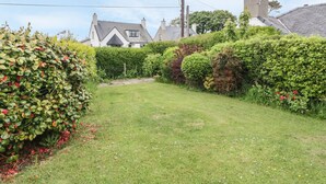 A well-maintained garden with a grassy lawn and various shrubs. - Bedlinog (Amlwch)