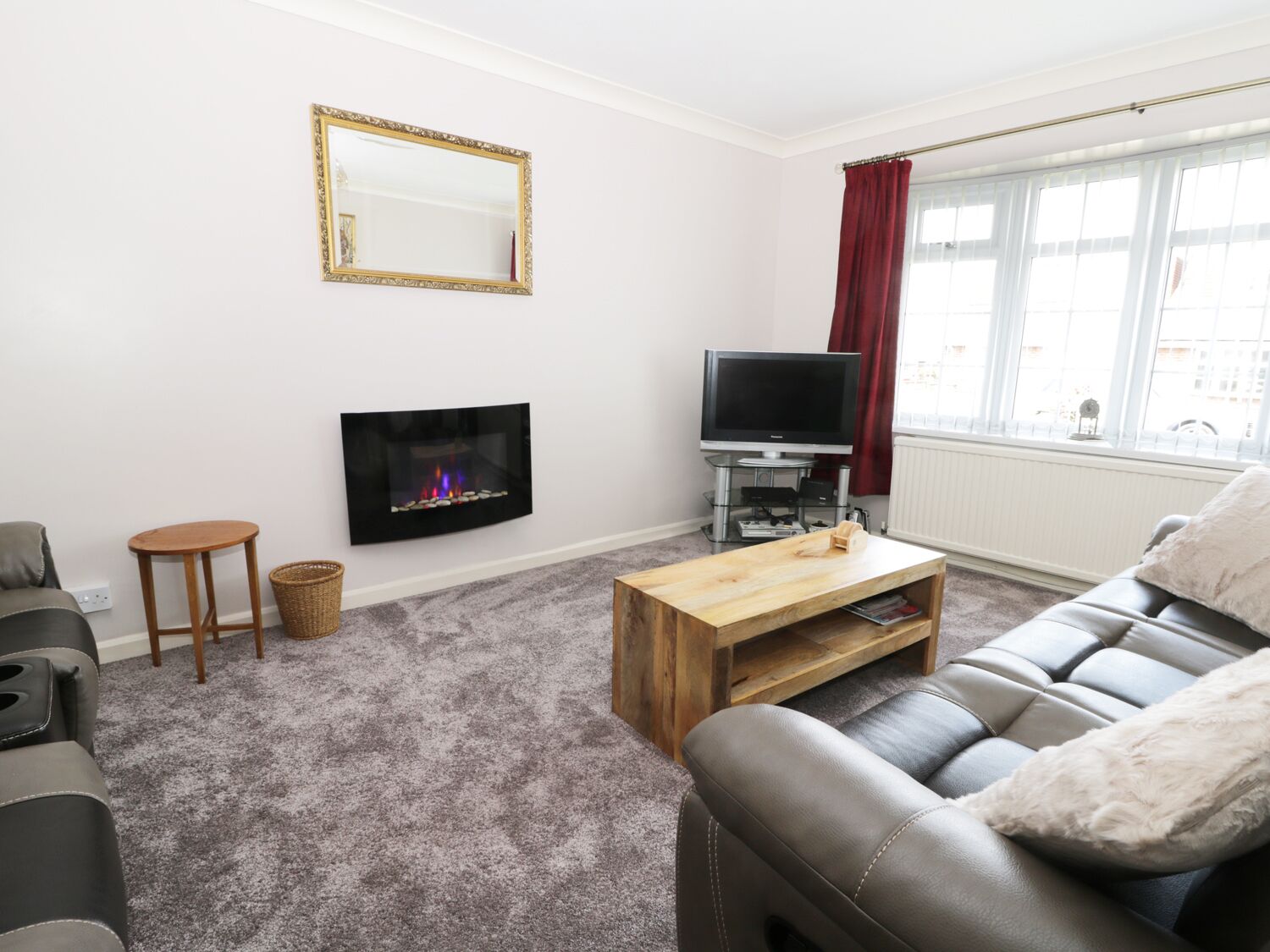 A living room with a fireplace, a television, a sofa, and a coffee table.