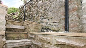 A stone staircase leading up to a stone wall.
