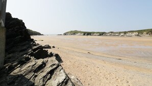 Une plage bordée de falaises rocheuses et dotée d’un rivage sablonneux.