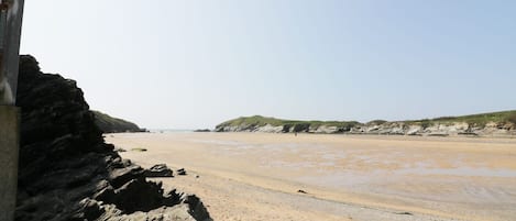A beach with rocky cliffs and a sandy shore.