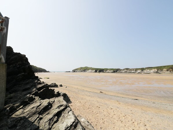 Ein Strand mit felsigen Klippen und einem Sandufer.