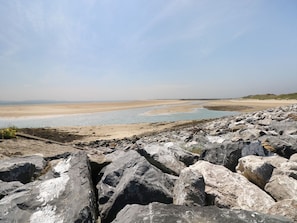 A rocky beach with a clear view of the sea and distant hills. - 5 Chandlers Yard (Burry Port)