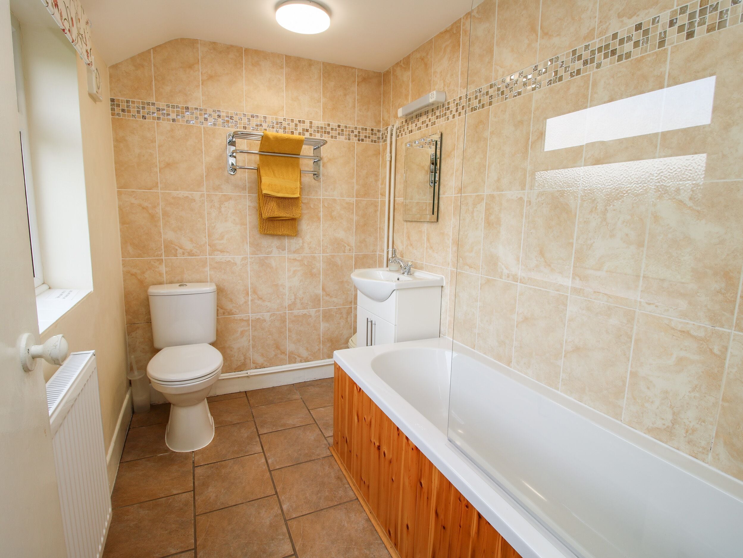 A bathroom with a toilet, sink, and bathtub.