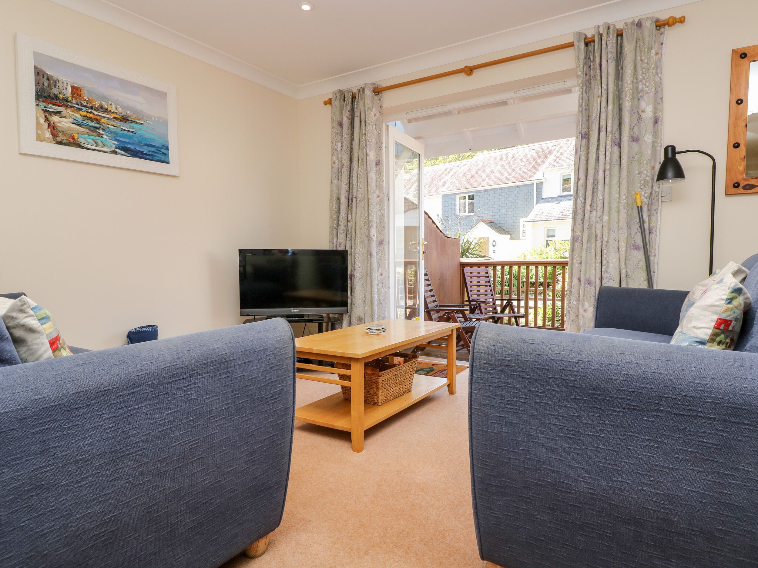 A living room with a sofa, TV, and a table.
