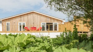 A wooden house with a balcony and red chairs. - Chy Lagen Hos (Newquay)