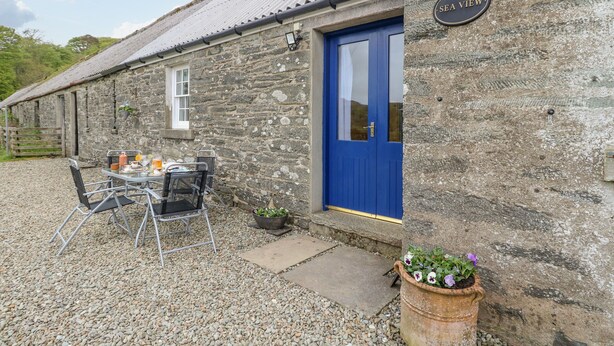 A stone building with a blue door labeled "SEA VIEW". - Seaview-barsloisnach Cottage (Lochgilphead)