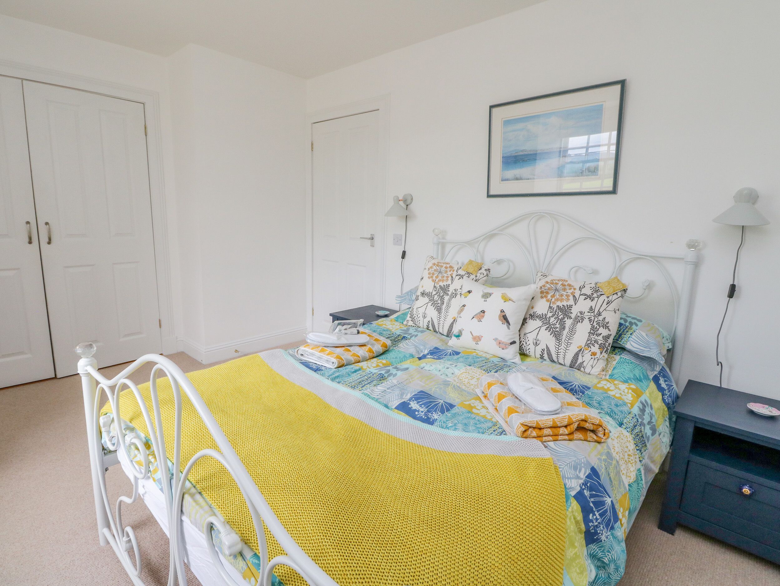 A neatly arranged bedroom with a bed, bedside tables, and a door.