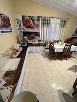 Un comedor con una barra alargada, sillas y una mesa dispuesta para una comida.