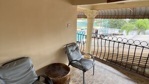 A room with two grey cushioned chairs, a woven stool, and a tiled floor. - Nalikwanda Guest House (Kabwe)
