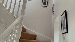 A staircase with white balusters and brown carpeted steps. - Solas (Sleat)