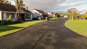 A residential street with houses, a parked car, and a clear sky. - Coneyville (Londonderry)