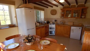 A cozy kitchen with wooden cabinets, a white refrigerator, a stove, and a dishwasher. - Jacobs Barn (Lifton)
